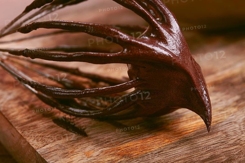 Metal whisk, close-up with chocolate dough, baking, structure and consistency, homemade, top view, no people