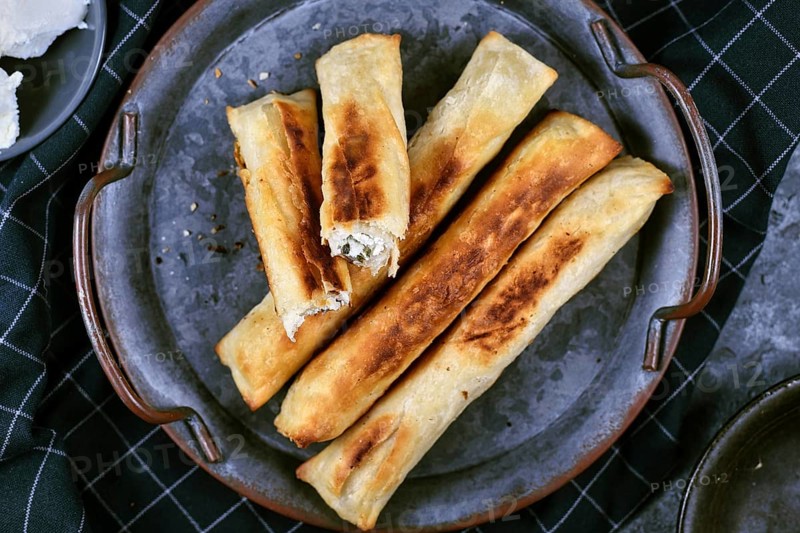 Fresh baked Börek, a baked filled pastries made of a thin flaky dough filled with sheep milk cheese from traditional Balkan cuisine