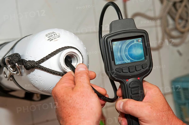 Checking visual inspection with mini camera and display of inside of gas pressure tank diving apparatus compressed air cylinder for diving by sport diver, Germany, Europe