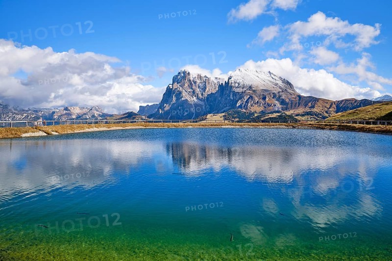 Snow-covered Plattkofel and Langkofel, lake with fish, reflection, Dolomites, Seiser Alm, snow, clouds and blue sky, Kastelruth, South Tyrol