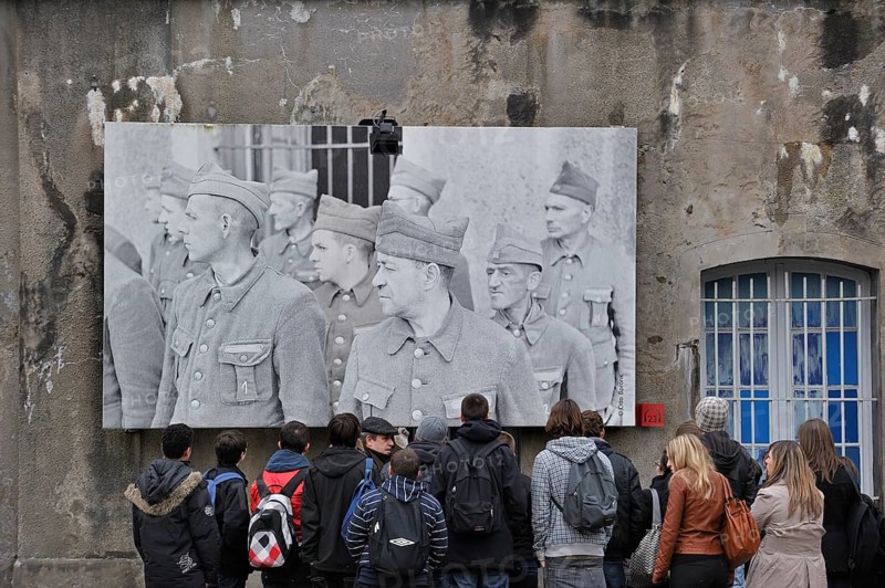 Students with guide in front of the picture of the political prisoners at Fort Breendonk, Belgium, Europe