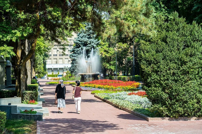 Strollers, flower bed in Panfilov Park, municipal park in Bishkek, Kyrgyzstan, Asia