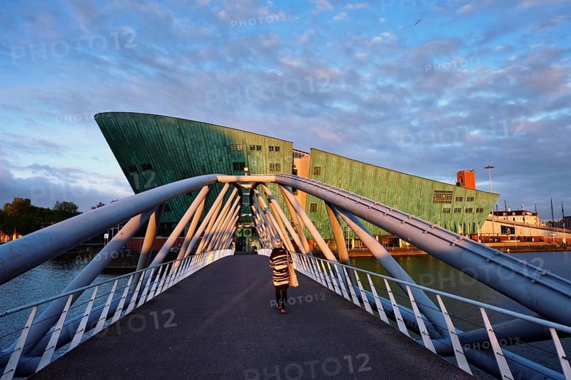 AMSTERDAM, NETHERLANDS, MAY 9, 2017: NEMO Science museum and Mr. J. van der Veldebrug bridge. It is the largest science center in Netherlands with over 500000 visitors per year
