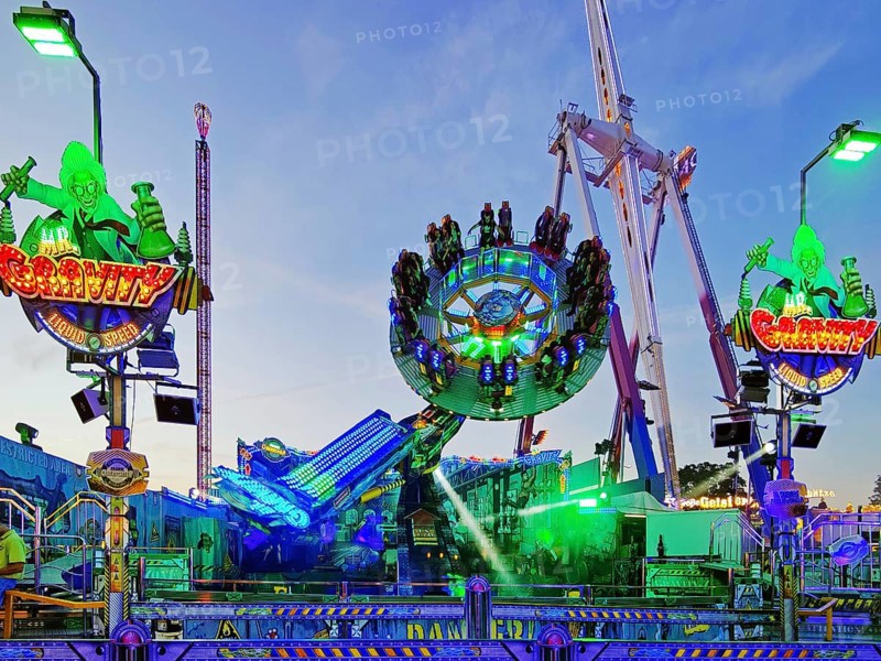 People on the illuminated carousel Mr Gravity in the evening, Cranger Kirmes, Herne, Ruhr area, North Rhine-Westphalia, Germany, Europe