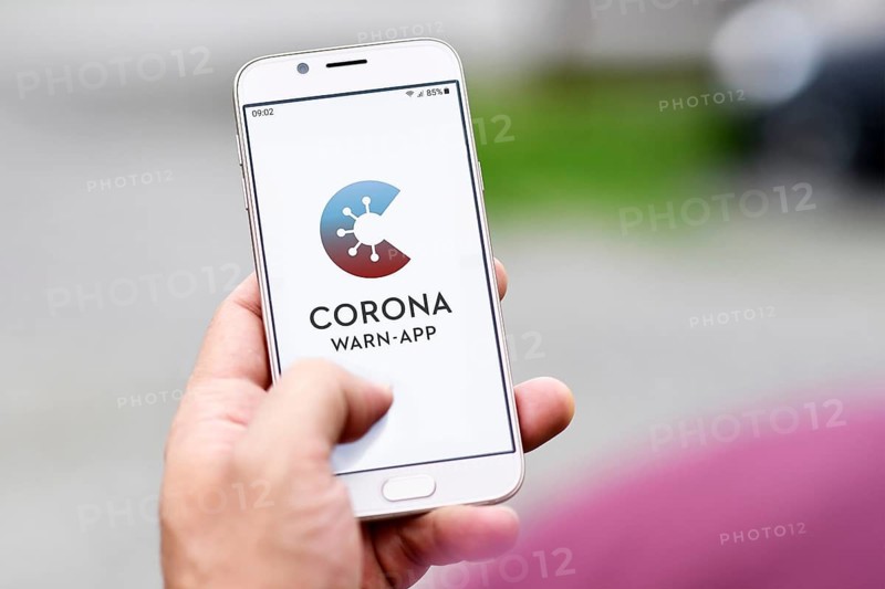 Germany, June 2020: Official German Corona Warning App on mobile phone held by hand on blurry background, Europe