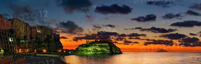 Panorama on the beach Lido Le Roccette Club Tropea with the old town of Tropea perched on rocks of sandstone and the medieval church Santuario di Santa Maria dell Isola at sunset and the volcanic island of Stomboli in the distance, Tropea, Vibo Valentia, Calabria, Southern Italy, Italy, Europe