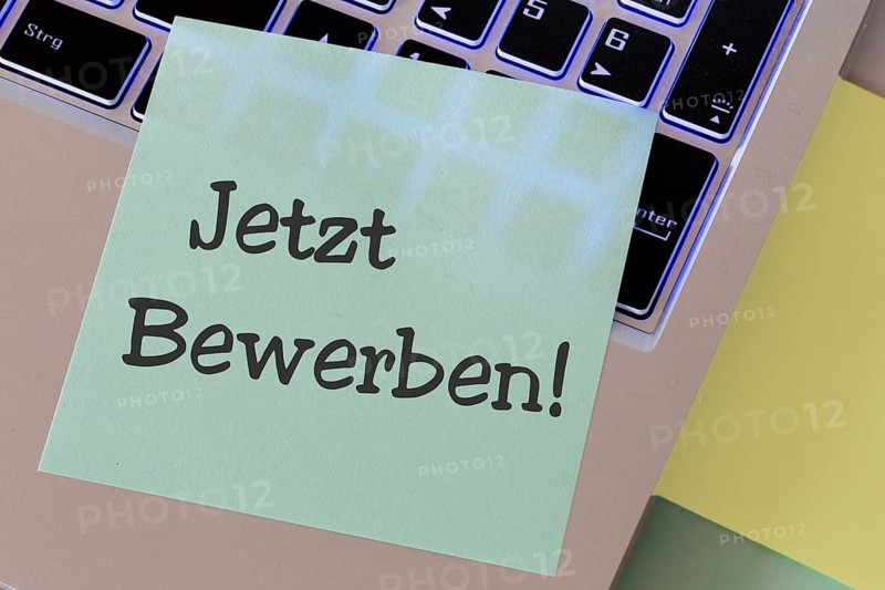 Notepad with the words APPLY NOW on a laptop