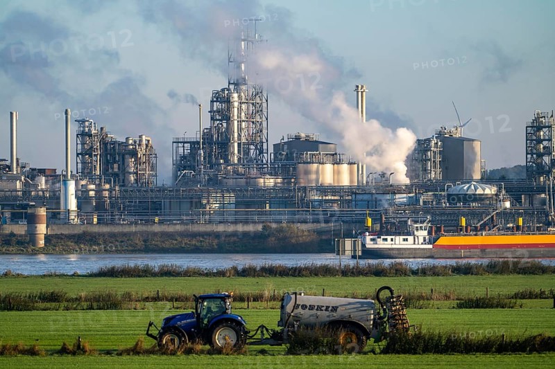 Cargo ship on the Rhine near Emmerich, Kao Chemicals backdrop, specialising in surfactants, KLK, Left Rhine pastures, tractor, slurry application, Lower Rhine, North Rhine-Westphalia, Germany, Europe
