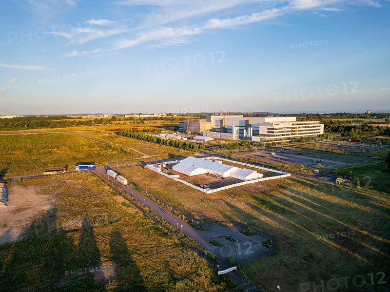 The Taiwanese chip manufacturer TSMC is building a new chip factory in Dresden together with Bosch, Infineon and NXP. The site is next to Bosch's new location in the north of Dresden. Construction of the new TSMC chip factory in Dresden is due to begin on 20 August. The chip manufacturer's CEO is also expected to attend the ground-breaking ceremony in Dresden. The plant is scheduled to open in 2027. Two heavily guarded tents behind a construction fence are the signs of the start of construction, aerial view TSMC site, Dresden, Saxony, Germany, Europe