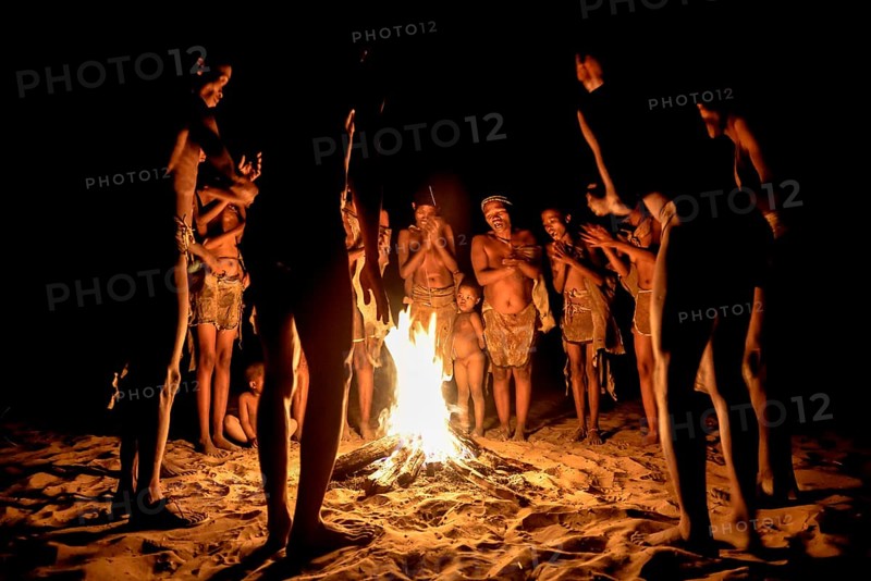 Bushmen of the Ju/' Hoansi-San stand by the campfire, village //Xa/oba, near Tsumkwe, Otjozondjupa region, Namibia, Africa