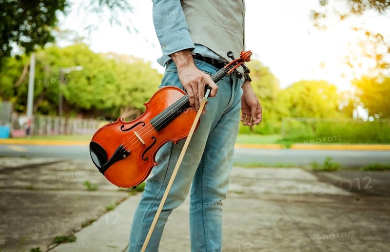 Hands holding violin and hoop outdoors, Close up of hands holding violin and hoop. Concept of person holding violin and hoop outdoors