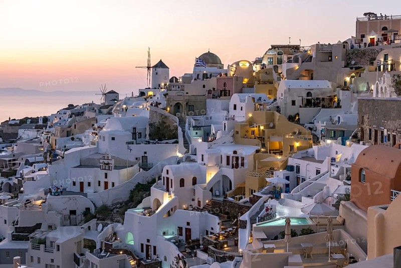 Cliff-side houses, villas and windmill in the village of Oia, Ia, at nightfall, Santorini, Greece, Europe