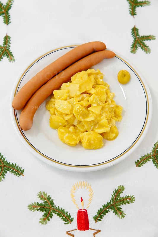 Swabian cuisine, potato salad with string sausages, Wienerle, Wiener sausages, thin boiled sausage, horseradish sausage, Frankfurter sausage, savoury, salty, typical Swabian, typical Christmas dinner, fast food for Christmas Eve, home cooking, plate, mustard, Christmas decoration, hand-embroidered table linen, Christmas motifs, fir branch motif, Christmas tablecloth, handmade, embroidered candle, traditional cuisine, food photography, studio, Germany, Europe