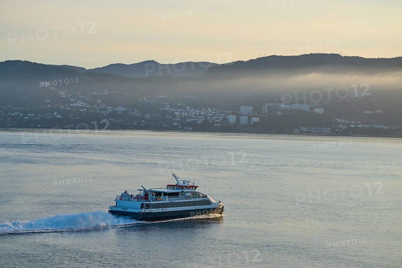 Ferry crossing the North Sea in the light of sunrise, with Bergen in the background, Bergen, Vestland, Norway, Europe