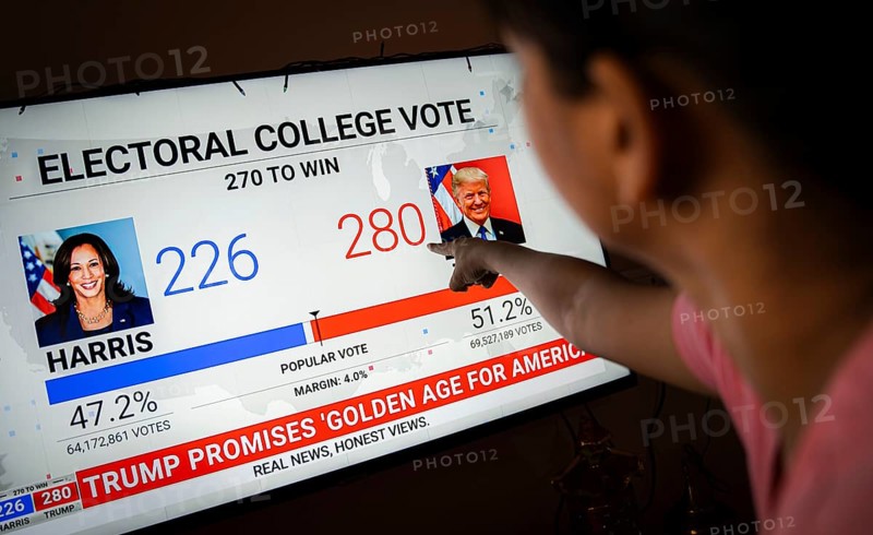 In this photo illustration, a person watch results of U.S. elections on a television in Guwahati, India on 6 November 2024. Donald Trump has won the 2024 US presidential election and a second term in the White House, four years after losing the 2020