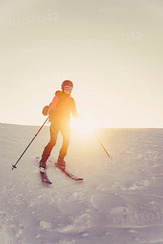 A woman's ski tour at sunrise on the Tegelberg in the Allgäu in the Ammergebirge, Bavaria, Germany, Europe