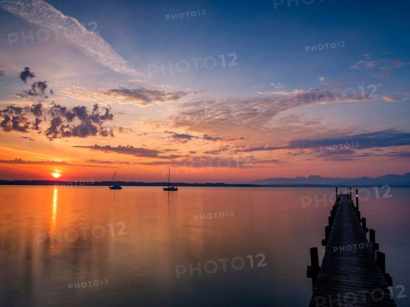 Sailing boats and jetty on Lake Chiemsee at sunrise, with the Chiemgau Alps in the background, Chiemgau, Upper Bavaria, Bavaria, Germany, Europe
