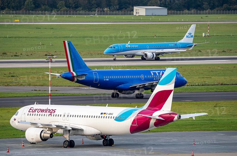 Düsseldorf Airport, KLM Cityhopper Embraer ERJ-190, lands, ITA Airways, Airbus A319-100, on the taxiway, Eurowings Airbus A320-200, at the outside position, parking position