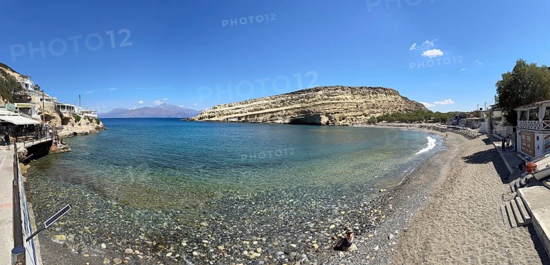 View of bay and beach of Matala with Libyan Sea Mediterranean on south coast of island Crete, in the background sandstone cliffs with former Roman necropolis in 60s 70s of 20th century hippie caves sandstone caves retreat of for dropouts, Matala, Crete, Greece, Europe