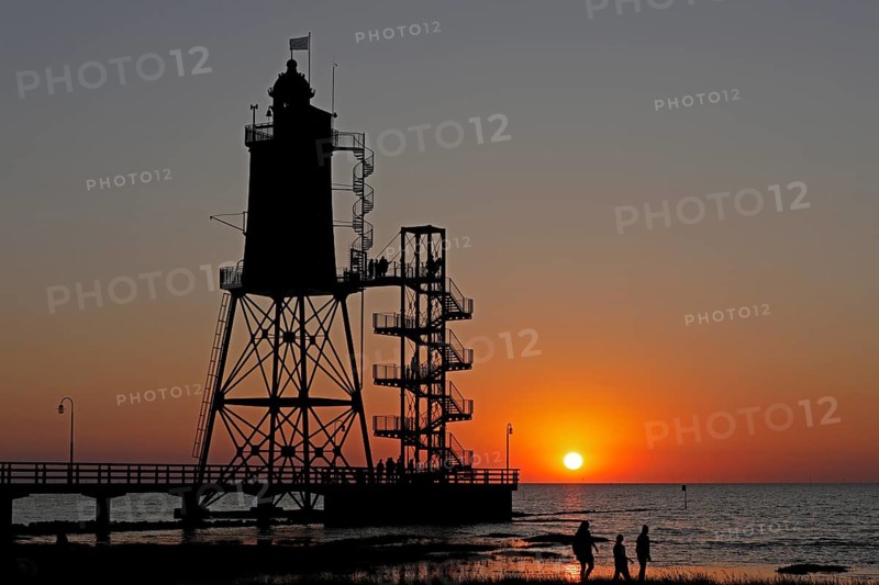 Sunset, lighthouse Obereversand, silhouettes, people, North Sea, Dorum-Neufeld, Wurster Land, Lower Saxony, Germany, Europe