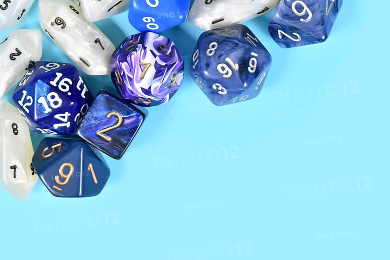 Different roleplaying RPG dice in upper corner of blue background with blank copy space