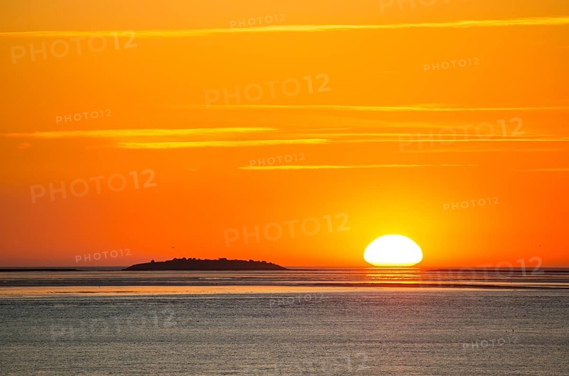 Picturesque, golden, magnificently beautiful sunset over the sea, Langlütjen II island far away, sun egg-shaped on the horizon, orange glowing cloudless sky, wide sea in soft colours, calm atmosphere, radiant light mood, mouth of the Weser into the North Sea, Outer Weser, Bremerhaven, Land Bremen, Germany Bremerhaven, Land Bremen, GermanyBremerhaven, Land Bremen, Germany, Europe