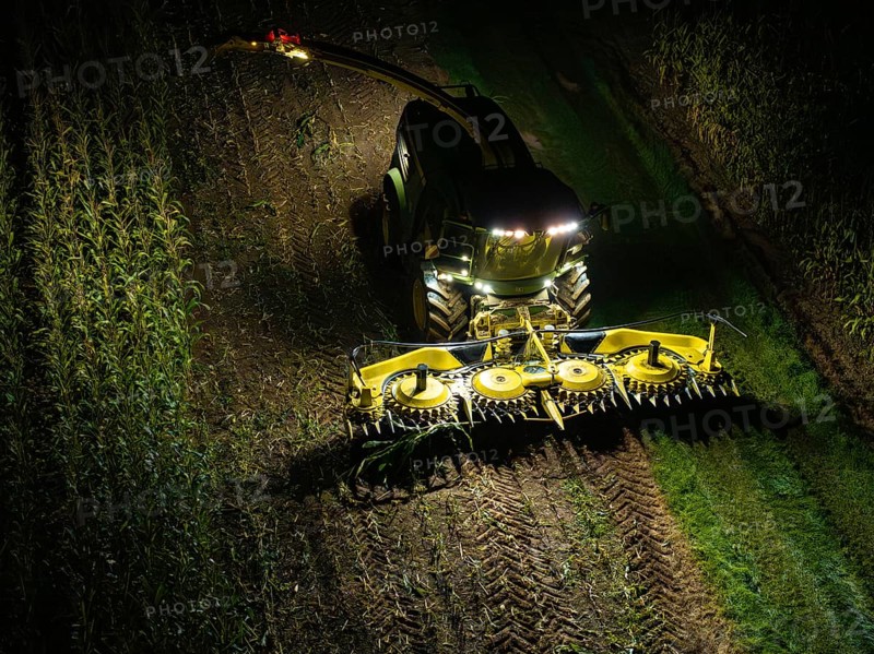 A combine harvester harvests a maize field at night, illuminated by floodlights, maize harvest, Dachtel, Black Forest, Germany, Europe