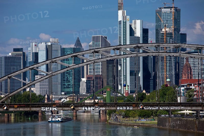 The river Main with the Deutschherrnbrücke bridge and a barge in front of the skyline of Frankfurt am Main, Hesse, Germany, Europe