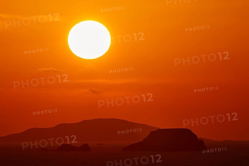 Intense sunset with a large, orange glowing sun over the ocean and islands, sunset, Kassos, Karpathos, offshore islands, Dodecanese, Greek Islands, Greece, Europe