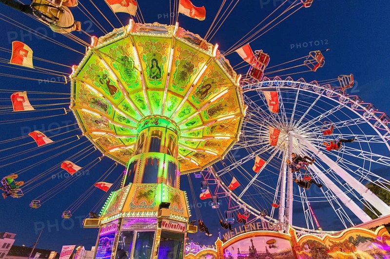 Illuminated carousel and Ferris wheel at night in a lively amusement park, funfair, wave flight, Cannstadter Volksfest, Stuttgart-Bad Cannstsdt, Baden-Württemberg