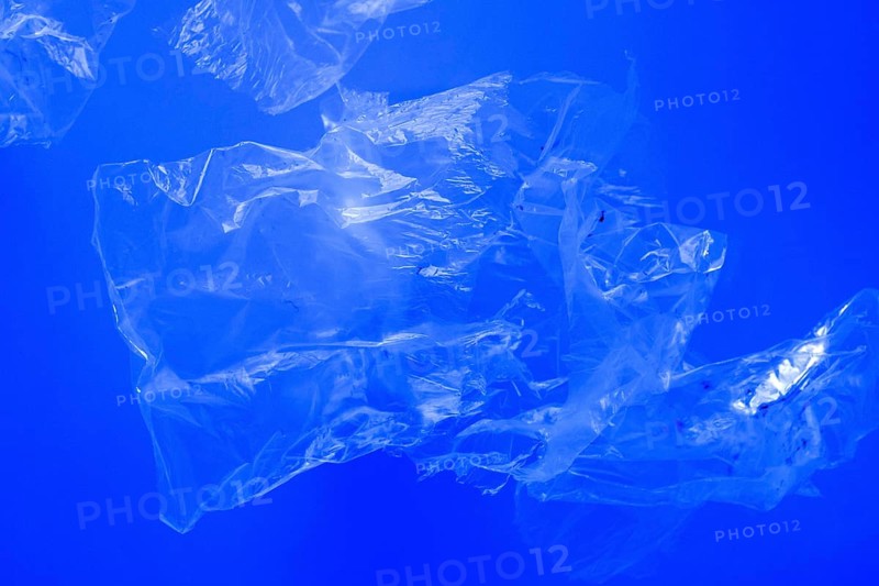 Transparent plastic bags floating underwater in blue ocean sea water, pollution by non-biodegradable plastic waste, hazard for marine wildlife