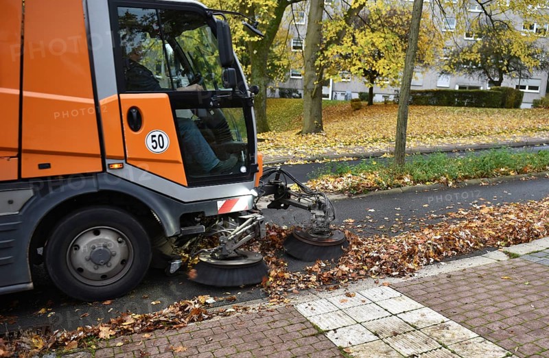 Sweeper sweeping wilted leaves in autumn, Vellmar, Hesse, Germany, Europe