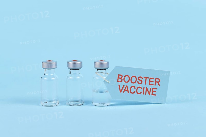 Corina virus booster vaccination concept with vial and syringe on blue background