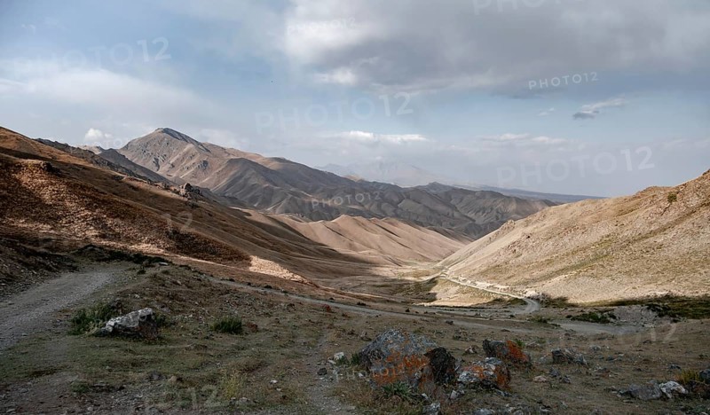 View of mountain landscape and pass road at Tyibel Pass, Song Kul Too mountain range, Naryn region, Kyrgyzstan, Asia