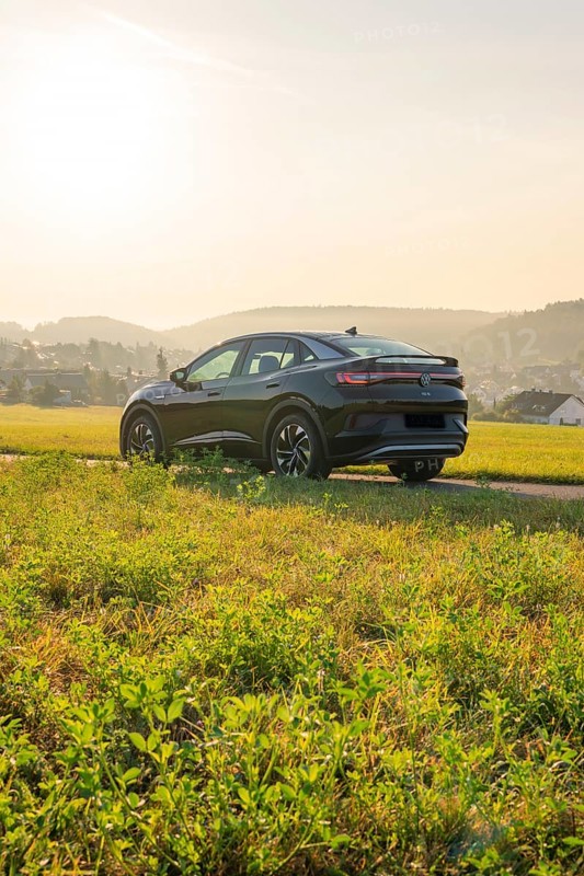 SUV on a rural road with a view of the hills in the background, at sunset, VW ID5 electric car, Calw, Black Forest, Germany, Europe