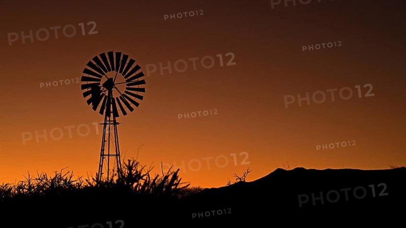 A wind-powered water pump at sunrise, Namibia, Africa