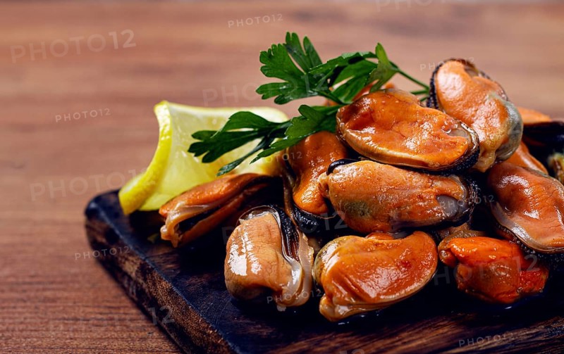 Mussels without shell, boiled, mussels, peeled, on a chopping board, with lemon and parsley, mussels in Chilean, top view, no people