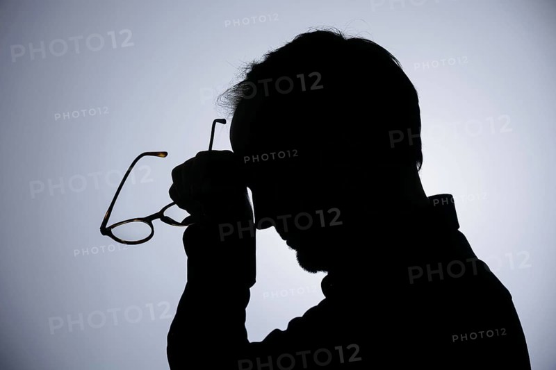Symbolic photo on the subject of overload. Silhouette of a man rubbing his aching head. Berlin, 22/08/2024