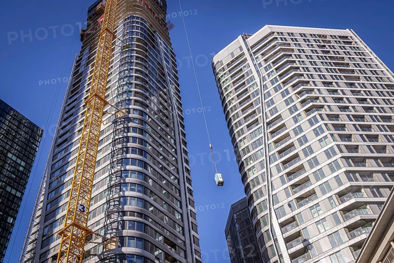 FOUR, four new tower blocks are being built here, Frankfurt 4 Tower construction site. A crane transports a portable toilet to the upper floors, Frankfurt am Main, Hesse, Germany, Europe