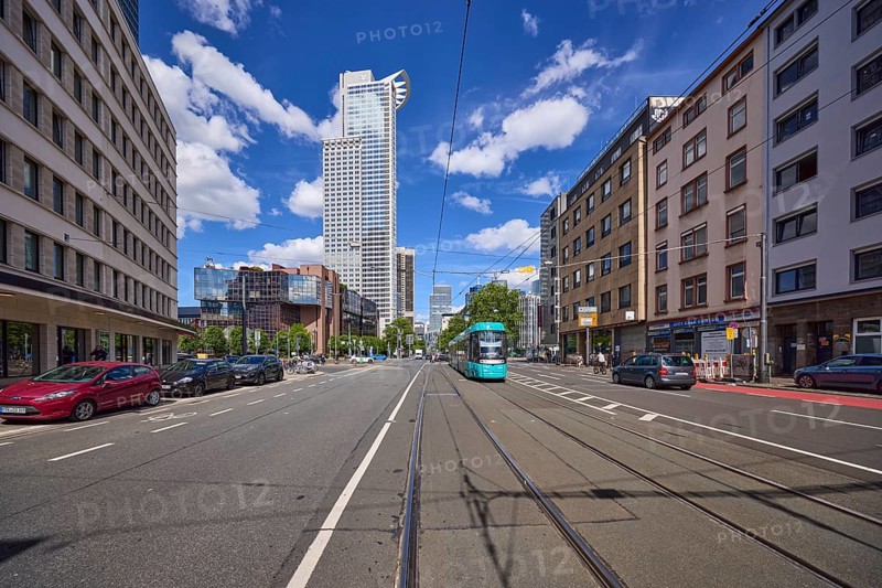 Kronenhochhaus or Westend 1, headquarters of DZ Bank, residential buildings and tram on Mainzer Landstraße under a blue sky with cumulus clouds in Frankfurt am Main, Hesse, Germany, Europe