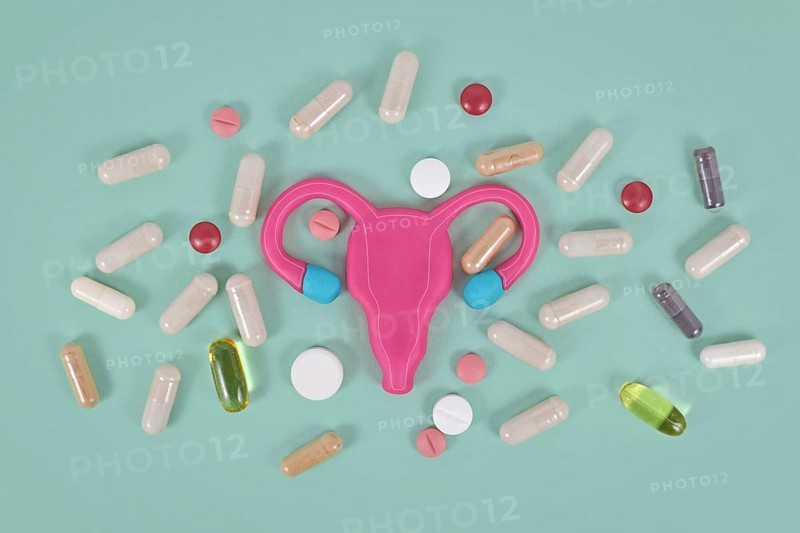 Concept for using medicine to boost female fertility showing stylized uterus and pills