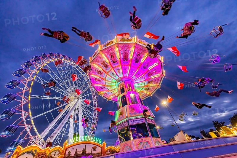 Chain carousel and Ferris wheel in the evening. 177th Cannstatter Volksfest at the Cannstatter Wasen. Bad Cannstatt, Stuttgart, Baden-Württemberg, Germany, Europe