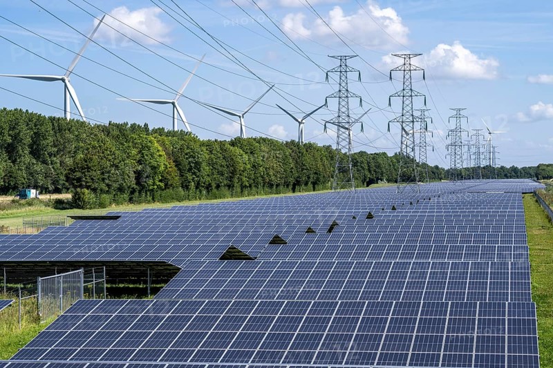 High-voltage power line route, the space underneath is used for a solar park over 5 km long, behind it a wind farm, in the harbour area of Vlissingen-Oost, Netherlands