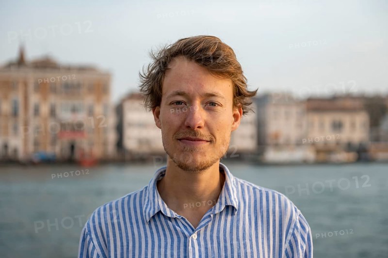 Young man in striped shirt, portrait, on the banks of the Grand Canal, looking into the camera, Venice, Veneto, Italy, Europe