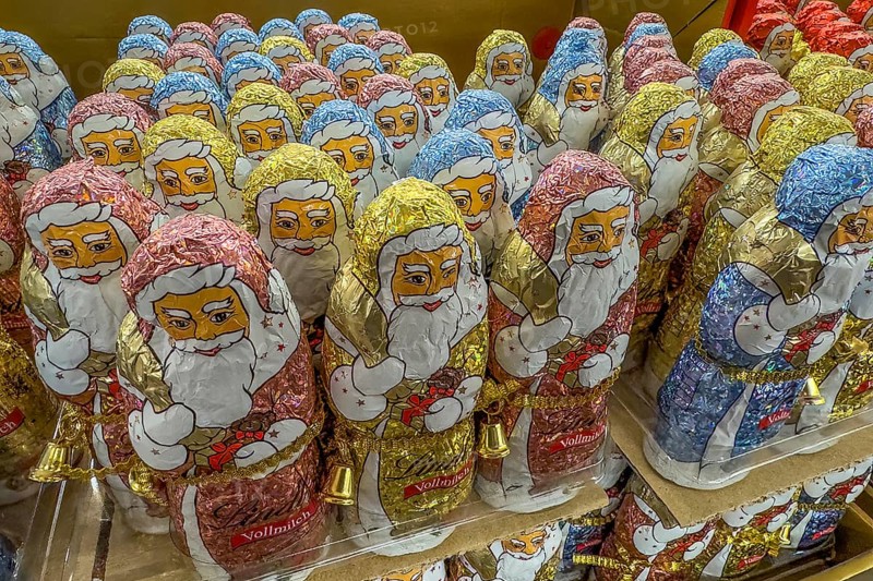 Display in shelf of wholesale of chocolate Father Christmases chocolate Father Christmases Father Christmas Father Christmas chocolate Father Christmases chocolate Father Christmases Father Christmases in colour blue gold of staniol paper of chocolate arranged like army of Father Christmas, Germany, Europe