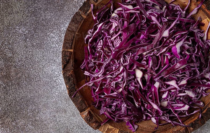 Red cabbage, sliced, in a wooden salad bowl, top view, no people