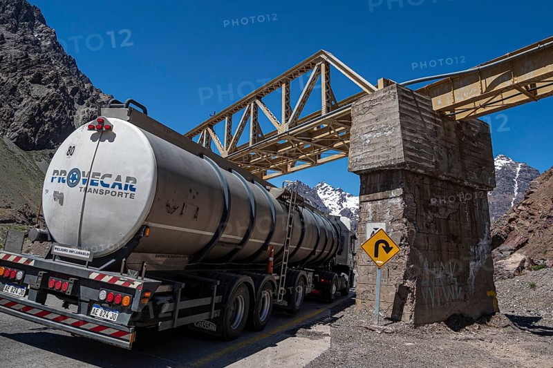 Truck driving under a bridge, mountain pass Los Caracoles, The Snails, road connecting Chile and Argentina, aerial view, Chile, South America