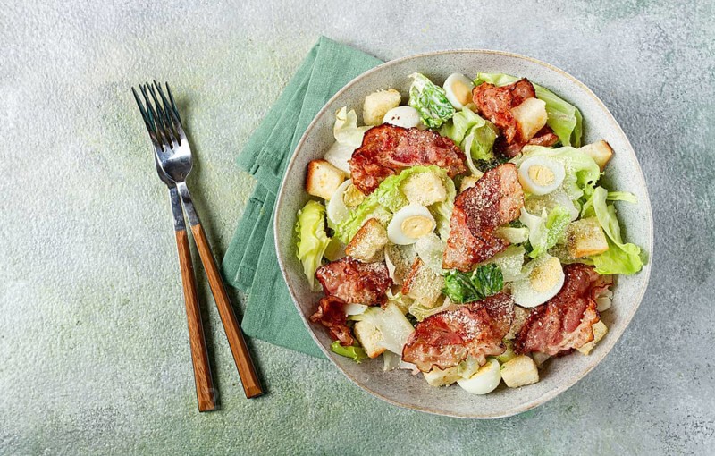 Caesar salad with fried bacon, quail eggs, homemade, no people