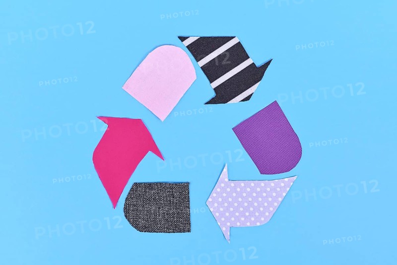 Textile recycling arrow symbol made from old clothing pieces