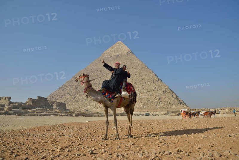 Camel owners on a camel in front of the Pyramid of Chephren, Giza, Egypt, Africa